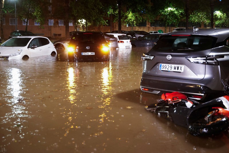 Kendaraan yang terendam sebagian tampak dikelilingi air banjir di tengah hujan, setelah otoritas setempat mengeluarkan peringatan cuaca di Valencia, Spanyol, pada 17 September 2026. (REUTERS/Eva Manez)
