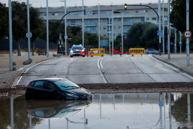 Kendaraan yang terendam sebagian tampak dikelilingi air banjir di tengah hujan, setelah otoritas setempat mengeluarkan peringatan cuaca di Valencia, Spanyol, pada 17 September 2026. (REUTERS/Eva Manez)