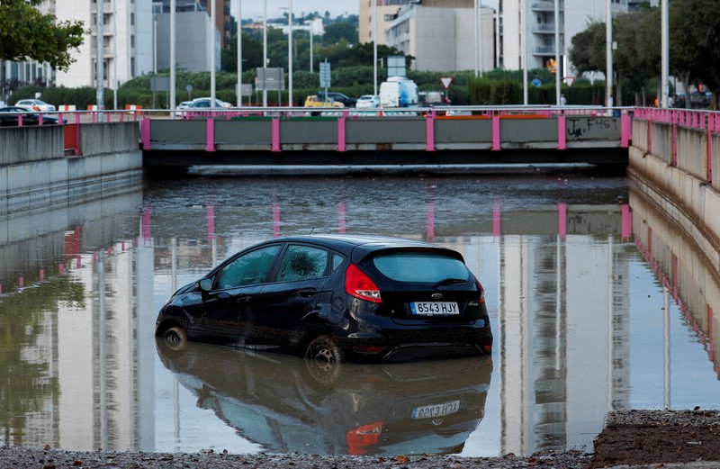Kendaraan yang terendam sebagian tampak dikelilingi air banjir di tengah hujan, setelah otoritas setempat mengeluarkan peringatan cuaca di Valencia, Spanyol, pada 17 September 2026. (REUTERS/Eva Manez)