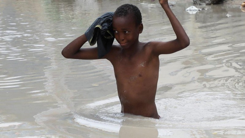 Seorang anak laki-laki menerjang air banjir di sepanjang jalan Km4 setelah hujan deras di Mogadishu, Somalia, pada 16 September 2026.