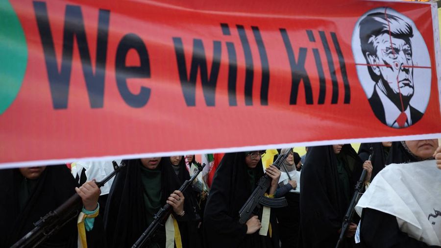 Anggota perempuan pasukan milisi Iran (Basij) membawa spanduk yang menentang Presiden AS Donald Trump saat pawai militer di Teheran, Iran, pada 18 September 2026.