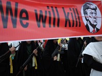 Anggota perempuan pasukan milisi Iran (Basij) membawa spanduk yang menentang Presiden AS Donald Trump saat pawai militer di Teheran, Iran, pada 18 September 2026. (Majid Asgaripour/WANA (West Asia News Agency) via REUTERS)