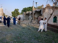Orang-orang berdiri di dekat ambulans dan bagian fasilitas kepolisian yang rusak setelah serangan bunuh diri di Kohat, Pakistan, pada 18 September 2026. (REUTERS/Stringer)