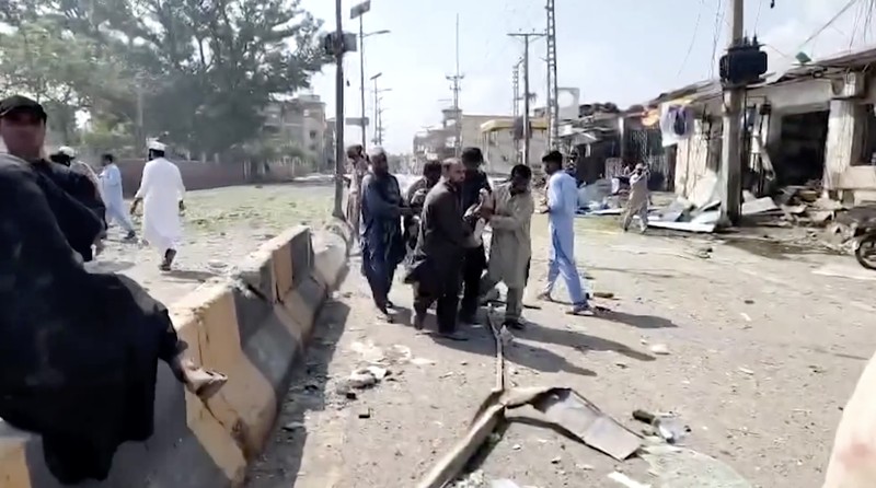 Orang-orang berdiri di dekat ambulans dan bagian fasilitas kepolisian yang rusak setelah serangan bunuh diri di Kohat, Pakistan, pada 18 September 2026. (REUTERS/Stringer)