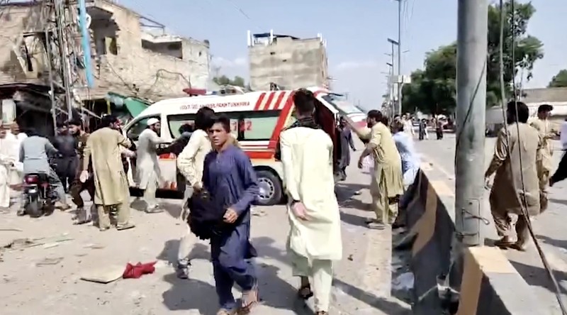 Orang-orang berdiri di dekat ambulans dan bagian fasilitas kepolisian yang rusak setelah serangan bunuh diri di Kohat, Pakistan, pada 18 September 2026. (REUTERS/Stringer)