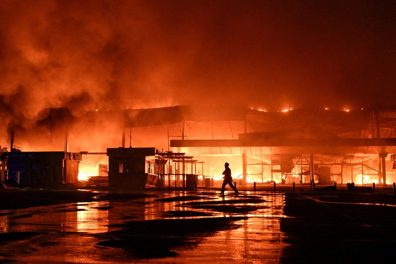 Seorang petugas pemadam kebakaran bekerja di lokasi pusat perbelanjaan yang dihantam serangan pesawat nirawak Rusia pada larut malam&mdash;di tengah serangan Rusia terhadap Ukraina&mdash;di Zaporizhzhia, Ukraina, pada 17 September 2026. (REUTERS/Stringer)
