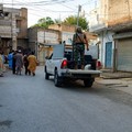 Warga dan sebuah kendaraan polisi berada di jalan setelah serangan bunuh diri di sebuah fasilitas kepolisian di Kohat, Pakistan, pada 18 September 2026. (REUTERS/Stringer)