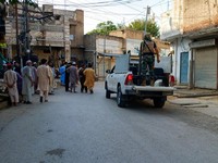Warga dan sebuah kendaraan polisi berada di jalan setelah serangan bunuh diri di sebuah fasilitas kepolisian di Kohat, Pakistan, pada 18 September 2026. (REUTERS/Stringer)