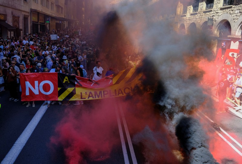 Seorang pengunjuk rasa membawa struktur berbentuk burung bangau saat warga berpartisipasi dalam protes menentang rencana perluasan Bandara Josep Tarradellas Barcelona-El Prat di Barcelona, ​​Spanyol, pada 20 September 2026. Pihak yang menentang proyek tersebut menyatakan bahwa perluasan itu akan merusak dua kawasan alam yang dilindungi, meningkatkan emisi gas rumah kaca, serta memicu pertumbuhan lebih lanjut di sektor pariwisata. (REUTERS/Nacho Doce)