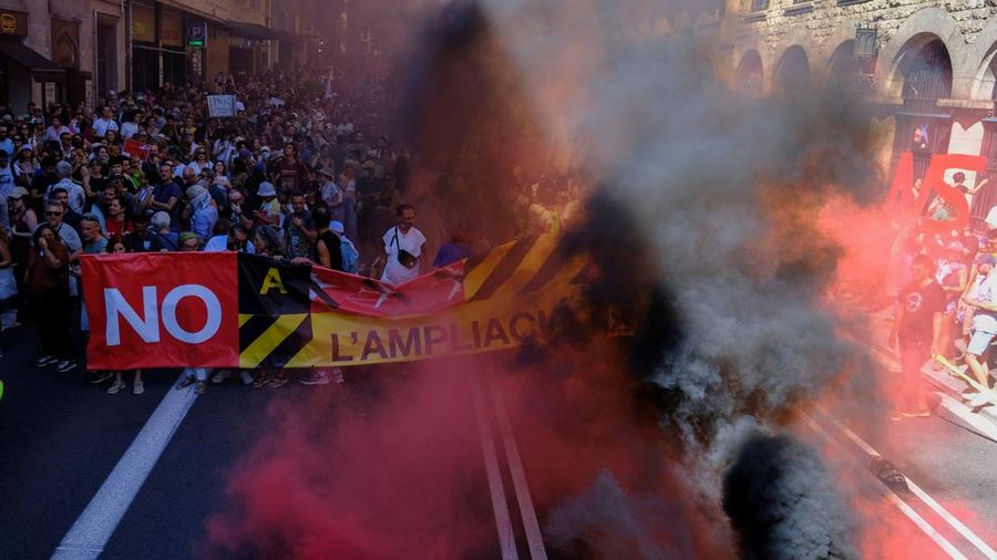 Asap dari suar membubung saat para pengunjuk rasa melakukan protes menentang rencana perluasan Bandara Josep Tarradellas Barcelona-El Prat di Barcelona, ​​Spanyol, pada 20 September 2026. Pihak yang menentang proyek tersebut menyatakan bahwa perluasan itu akan merusak dua kawasan alam yang dilindungi, meningkatkan emisi gas rumah kaca, serta memicu pertumbuhan pariwisata yang tidak berkelanjutan.