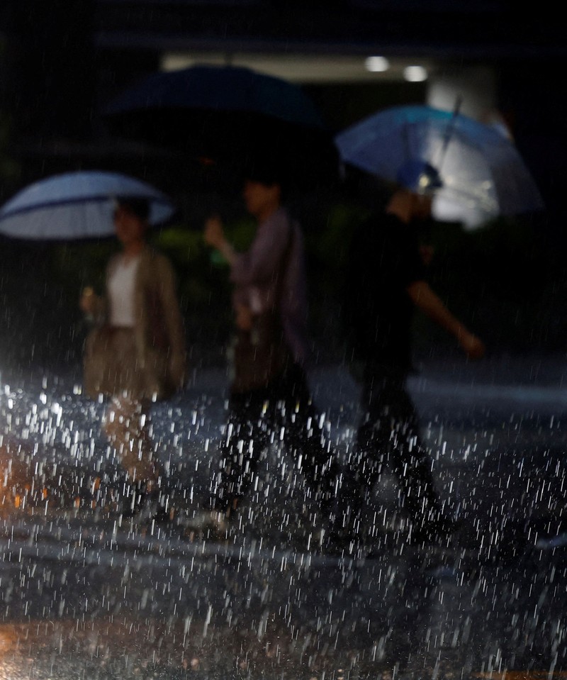 Para penumpang beristirahat di Bandara Haneda karena banyak penerbangan tertunda dan dibatalkan akibat Topan Dujuan, di Tokyo, Jepang, Senin (21/9/2026). (REUTERS/Kim Kyung-Hoon)