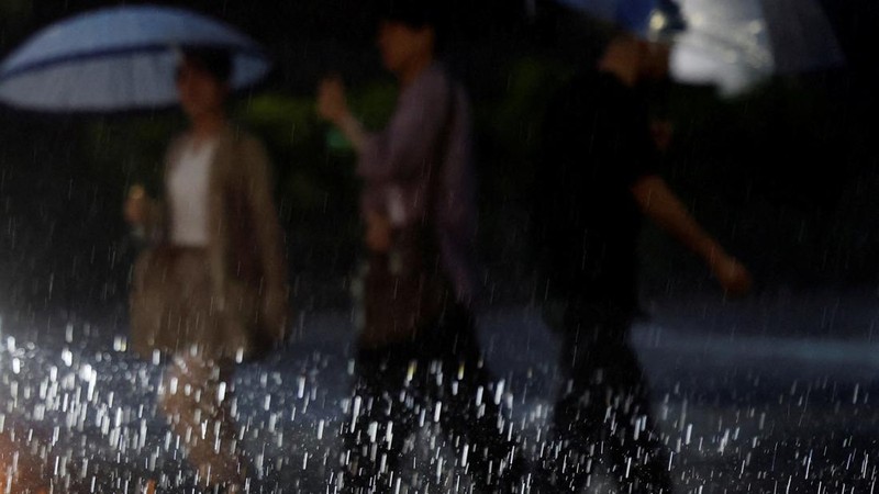 ASIA-WEATHER/JAPANPejalan kaki menyeberang jalan di tengah hujan deras akibat Topan Dujuan di Tokyo, Jepang, Senin (21/9/2026). (REUTERS/Kim Kyung-Hoon)