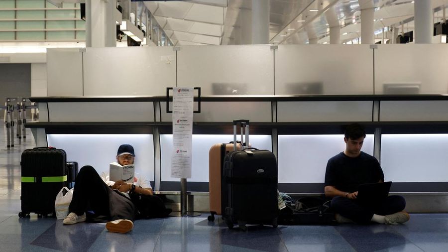 Para penumpang beristirahat di Bandara Haneda karena banyak penerbangan tertunda dan dibatalkan akibat Topan Dujuan, di Tokyo, Jepang, Senin (21/9/2026). (REUTERS/Kim Kyung-Hoon)
