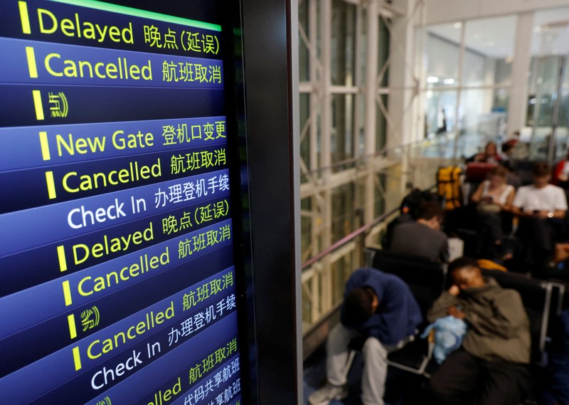 Para penumpang beristirahat di Bandara Haneda karena banyak penerbangan tertunda dan dibatalkan akibat Topan Dujuan, di Tokyo, Jepang, Senin (21/9/2026). (REUTERS/Kim Kyung-Hoon)