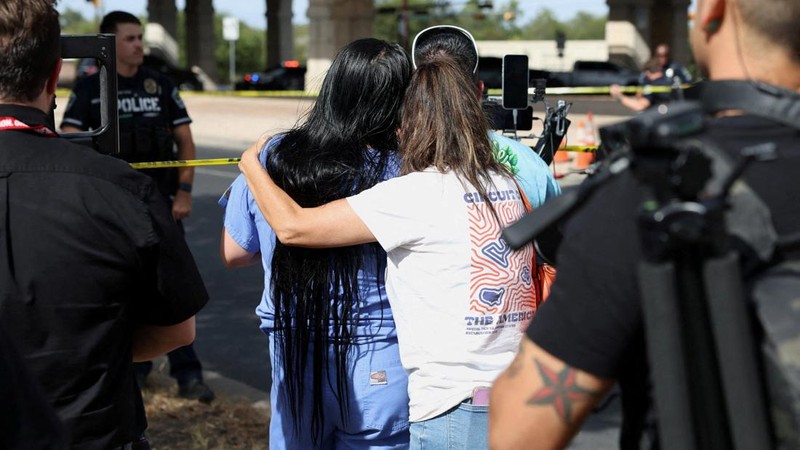 Sejumlah warga saling menenangkan diri sembari melihat ke arah garis polisi setelah Anggota Kongres Greg Casar (Demokrat-Texas) menyatakan bahwa seorang agen Imigrasi dan Penegakan Bea Cukai AS (ICE) menembak seseorang pada hari itu di Austin, Texas, AS, 20 September 2026.