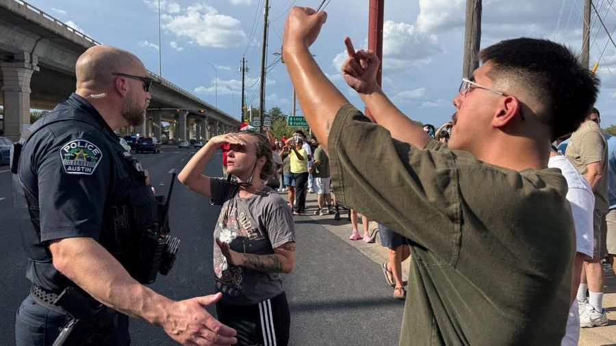 Seorang pengunjuk rasa mengarahkan isyarat kepada petugas Kepolisian Austin setelah seorang petugas imigrasi federal menembak dan melukai seorang pria—menurut keterangan pejabat kota—di Austin, Texas, AS, pada 20 September 2026. Foto diambil menggunakan ponsel.