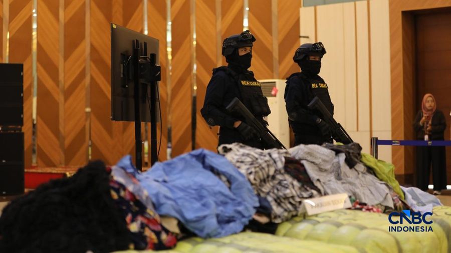 Petugas keamanan berdiri di depan barang bukti Balpres atau pakaian bekas yang ditampilkan dalam Konferensi Pers Penindakan Impor Ilegal Beras, Garam, dan Balpres di Kantor Pusat Bea Cukai, Jakarta, Selasa (22/9/2026).