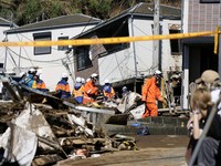 Petugas penyelamat melakukan operasi pencarian dan penyelamatan terhadap seseorang yang hilang di sebuah rumah yang tertimpa tanah longsor akibat Topan Dujuan di Miura, Prefektur Kanagawa, Jepang, pada 22 September 2026, dalam foto yang diambil oleh