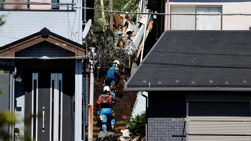 Petugas penyelamat menyingkirkan puing-puing sembari mencari seorang korban hilang di sebuah rumah yang tertimpa tanah longsor akibat Topan Dujuan di Miura, Prefektur Kanagawa, Jepang, pada 22 September 2026.