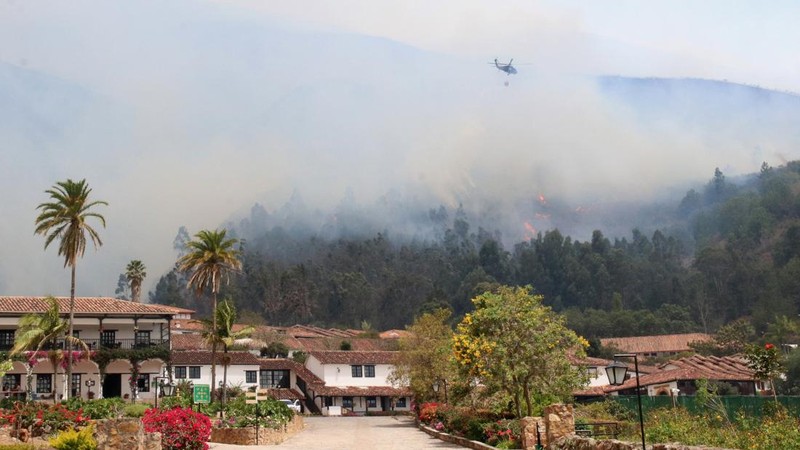 Sebuah helikopter terbang di atas kebakaran hutan yang berkobar di dekat permukiman di Villa de Leyva, Kolombia, pada 20 September 2026.