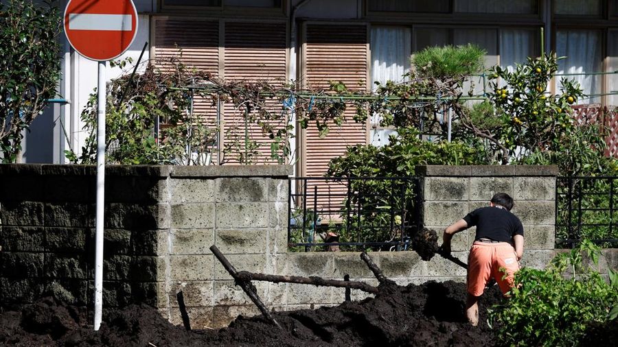 Seorang warga membersihkan lumpur di jalan dekat sebuah rumah yang tertimpa tanah longsor akibat Topan Dujuan di Miura, Prefektur Kanagawa, Jepang, pada 22 September 2026.