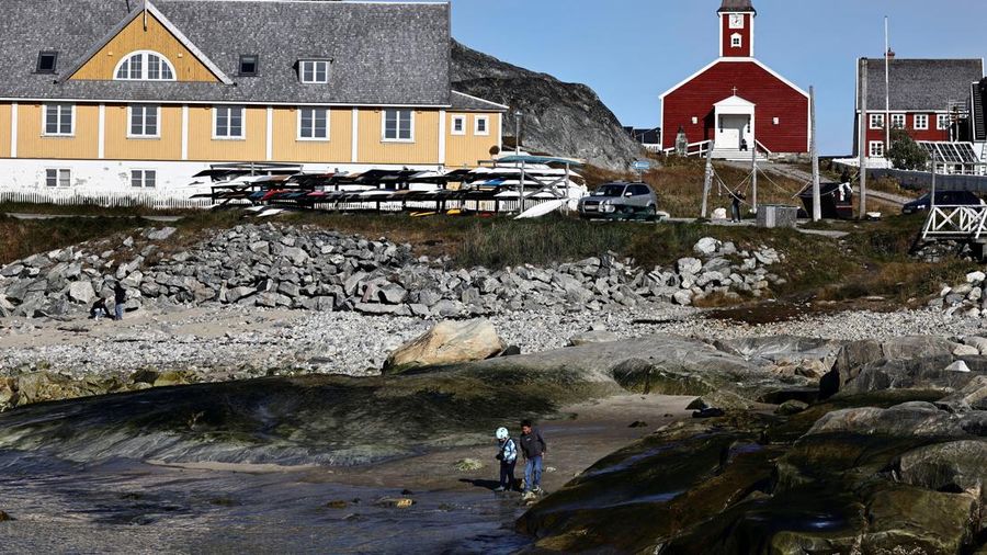 Dua anak bermain di pantai di kawasan pelabuhan lama Nuuk, Greenland, pada 22 September 2026.