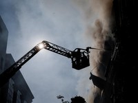 Seorang petugas pemadam kebakaran bekerja di lokasi pusat bisnis yang dihantam serangan pesawat nirawak Rusia, di tengah serangan Rusia terhadap Ukraina di Kyiv, Ukraina, pada 23 September 2026. (REUTERS/Gleb Garanich)