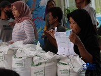 Warga mengantre untuk mengambil bantuan pangan berupa beras kepada masyarakat di Balai RW 03, Kelurahan Menteng, Jakarta, Rabu (23/9/2026). (CNBC Indonesia/Muhammad Sabki)