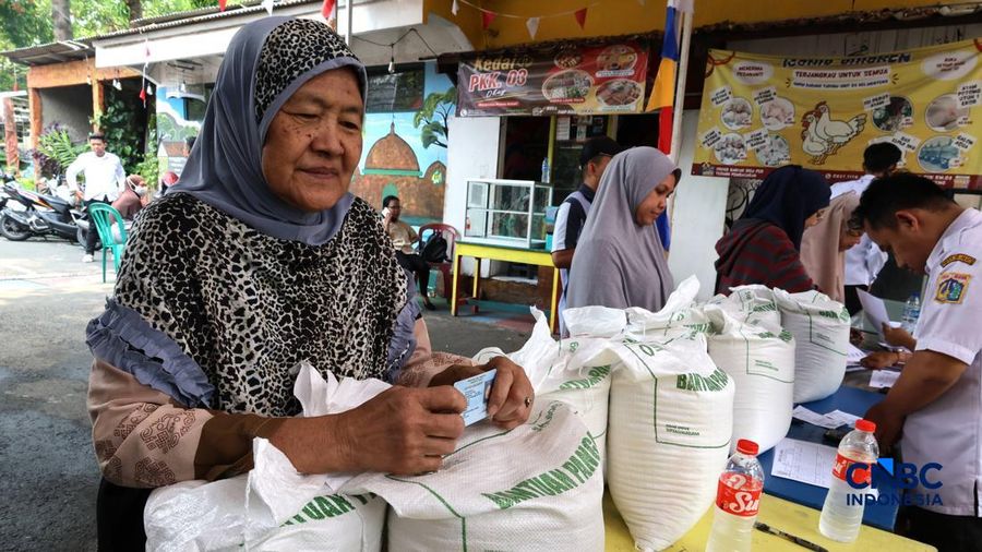 Warga mengantre untuk mengambil bantuan pangan berupa beras kepada masyarakat di Balai RW 03, Kelurahan Menteng, Jakarta, Rabu (23/9/2026).