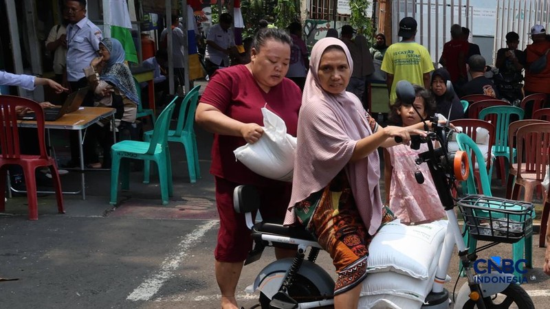 Warga mengantre untuk mengambil bantuan pangan berupa beras kepada masyarakat di Balai RW 03, Kelurahan Menteng, Jakarta, Rabu (23/9/2026).