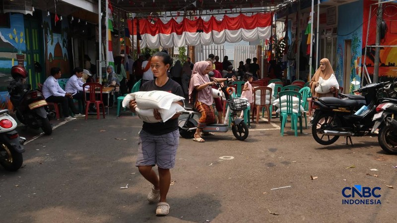 Warga mengantre untuk mengambil bantuan pangan berupa beras kepada masyarakat di Balai RW 03, Kelurahan Menteng, Jakarta, Rabu (23/9/2026).