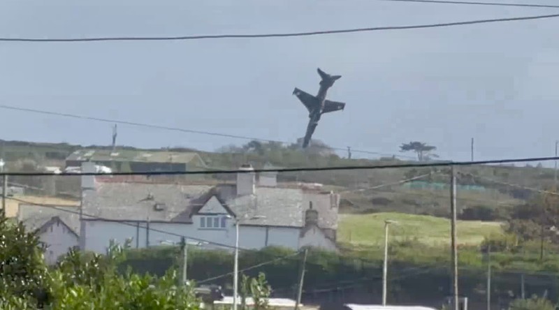 Pesawat Hawk T2 mengeluarkan asap sebelum jatuh di dekat rumah-rumah dan bangunan pertanian, melontarkan bola api ke angkasa. (Tangkapan Layar Video Facebook/John Heyworth)