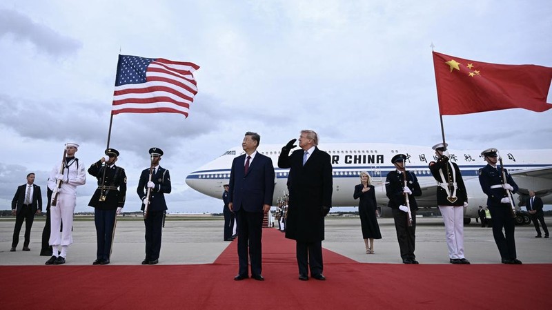 Presiden AS Donald Trump bereaksi saat sebuah pesawat pengebom B-1 melintas di tengah berkumandangnya lagu kebangsaan, ketika ia menyambut Presiden China Xi Jinping yang tiba di Pangkalan Gabungan Andrews di Maryland, AS, Rabu (23/9/2026). (Brendan SMIALOWSKI / AFP)