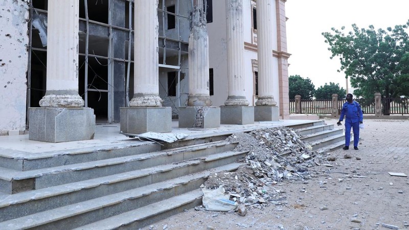 Seorang petugas polisi Sudan berjaga di depan gedung Pengadilan Kota Um Rawaba setelah serangan pesawat nirawak (drone)yang diduga dilakukan oleh kelompok paramiliter Rapid Support Forces (RSF)menghantam gedung pengadilan tersebut,