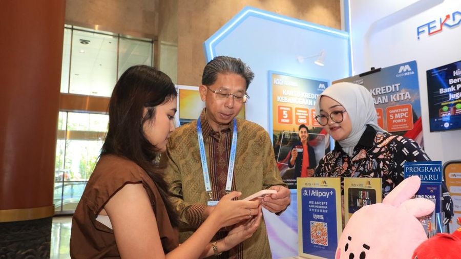 Direktur Utama Bank Mega, Kostaman Thayib (tengah) menyaksikan pengunjung yang tengah melakukan transaksi pembayaran menggunakan QRIS Cross Border - Korea Selatan dan QRIS Cross Border  Tiongkok (Cina) yang kini telah dapat dilakukan melalui aplikasi