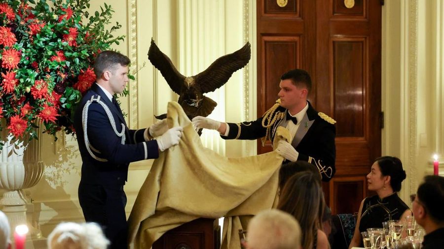Trump memberi Xi hadiah berupa patung elang botak yang dibuat khusus -- simbol nasional Amerika Serikat. Para tamu bersantap dengan veloute labu kuning, ikan bass berkulit wijen, dan vanilla cremeux dengan es krim madu Gedung Putih.(Photo by Kevin Di