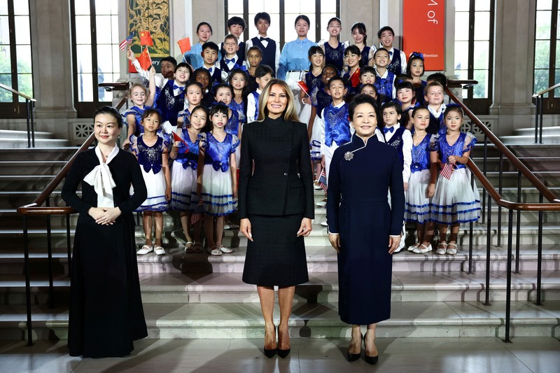 First lady of China Peng Liyuan and U.S. first lady Melania Trump react as choir students from the Hope Chinese School perform during a visit to the Smithsonian's National Museum Of Asian Art from Director of the museum Chase Robinson in Washington, D.C., US, September 24, 2026. Finn Gomez/Pool via REUTERS