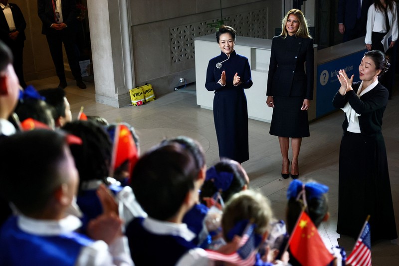 First lady of China Peng Liyuan and U.S. first lady Melania Trump react as choir students from the Hope Chinese School perform during a visit to the Smithsonian's National Museum Of Asian Art from Director of the museum Chase Robinson in Washington, D.C., US, September 24, 2026. Finn Gomez/Pool via REUTERS