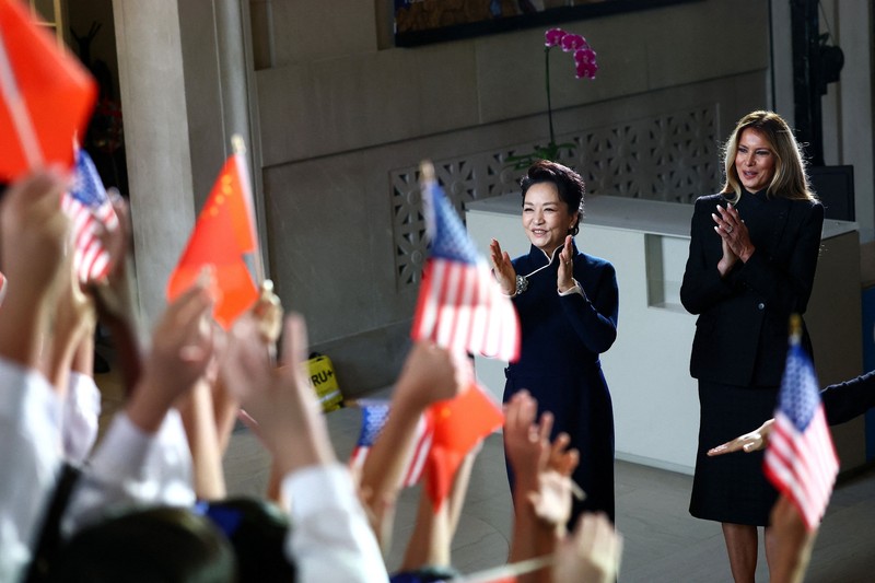 First lady of China Peng Liyuan and U.S. first lady Melania Trump react as choir students from the Hope Chinese School perform during a visit to the Smithsonian's National Museum Of Asian Art from Director of the museum Chase Robinson in Washington, D.C., US, September 24, 2026. Finn Gomez/Pool via REUTERS