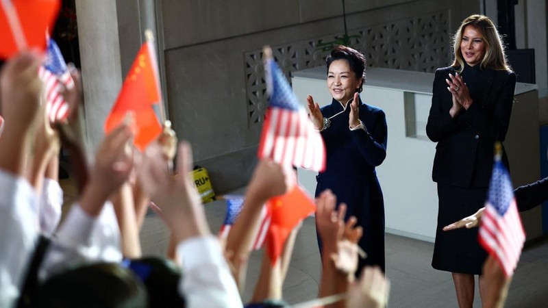 First lady of China Peng Liyuan and U.S. first lady Melania Trump react as choir students from the Hope Chinese School perform during a visit to the Smithsonian's National Museum Of Asian Art from Director of the museum Chase Robinson in Washington,