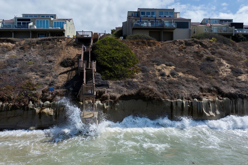 A drone view shows waves crashing into a boardwalk in Long Beach, California, US, September 16, 2026. REUTERS/Daniel Cole