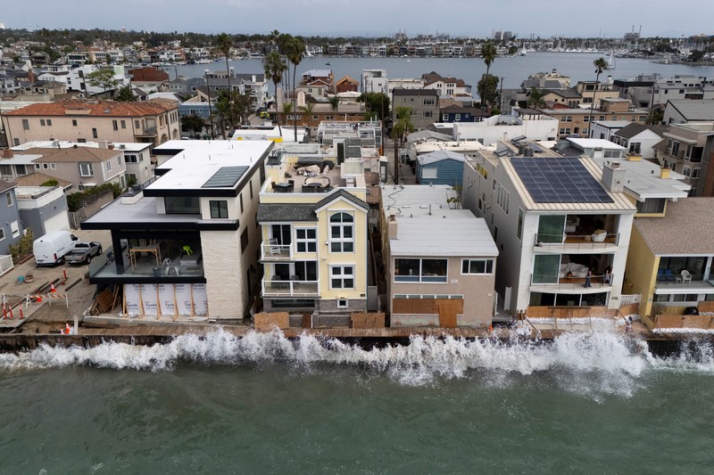 A drone view shows waves crashing into a boardwalk in Long Beach, California, US, September 16, 2026. REUTERS/Daniel Cole