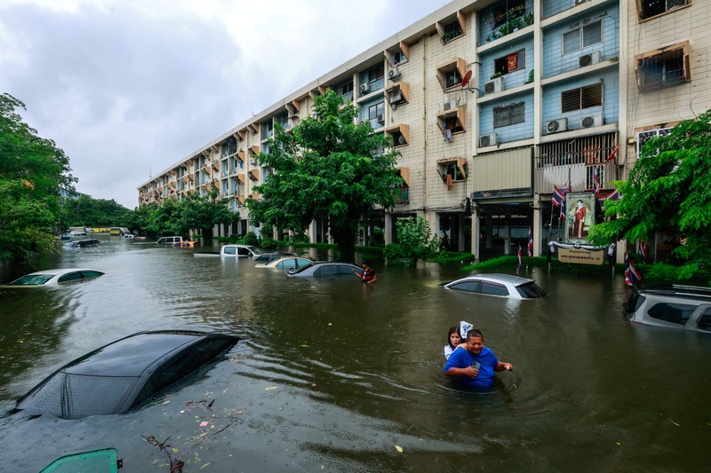 People wade through a flooded street during heavy rain in Bangkok, Thailand, September 26, 2026. REUTERS/Patipat Janthong