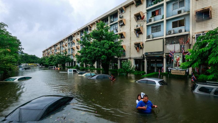 People wade through a flooded street during heavy rain in Bangkok, Thailand, September 26, 2026. REUTERS/Patipat Janthong