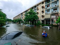 People wade through a flooded street during heavy rain in Bangkok, Thailand, September 26, 2026. REUTERS/Patipat Janthong