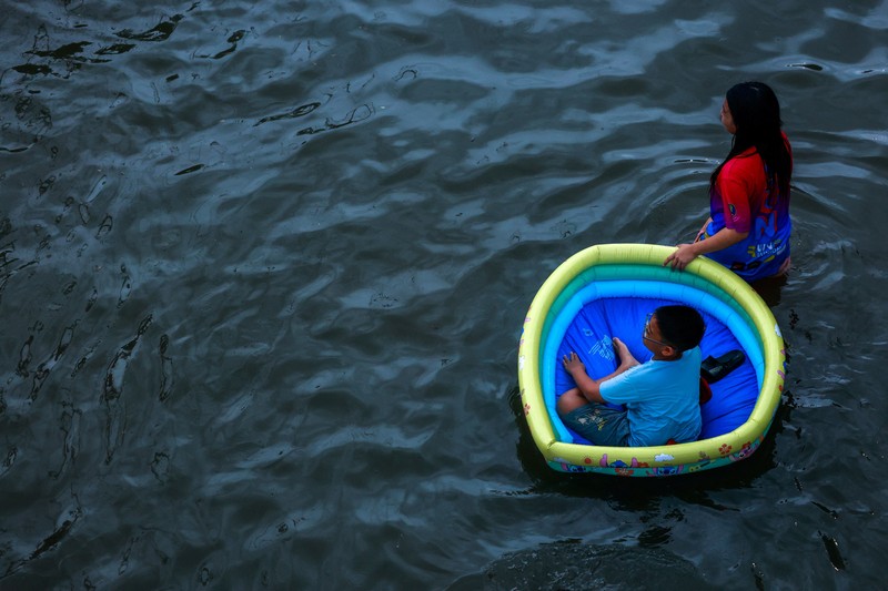 People wade through a flooded street during heavy rain in Bangkok, Thailand, September 26, 2026. REUTERS/Patipat Janthong