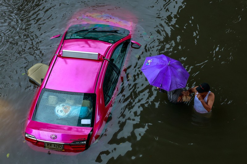 People wade through a flooded street during heavy rain in Bangkok, Thailand, September 26, 2026. REUTERS/Patipat Janthong