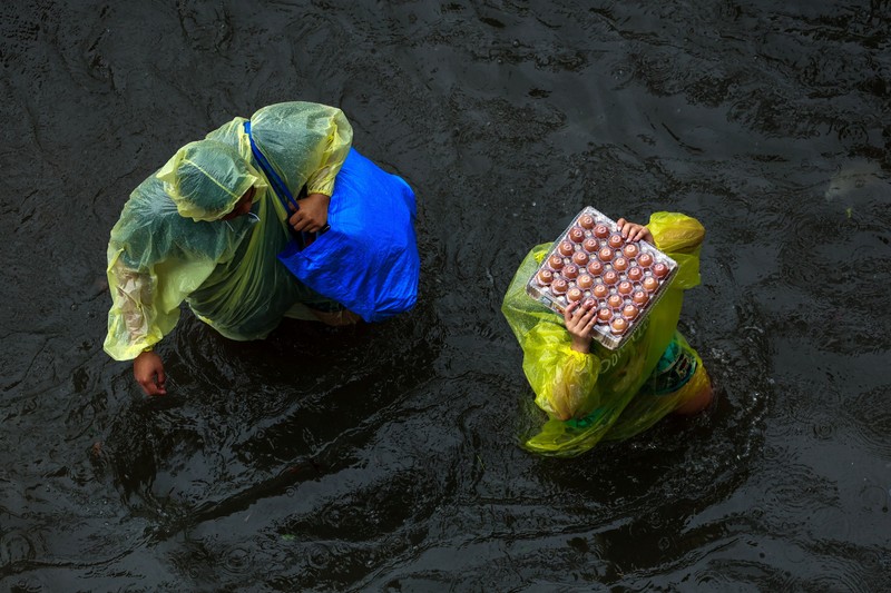 People wade through a flooded street during heavy rain in Bangkok, Thailand, September 26, 2026. REUTERS/Patipat Janthong