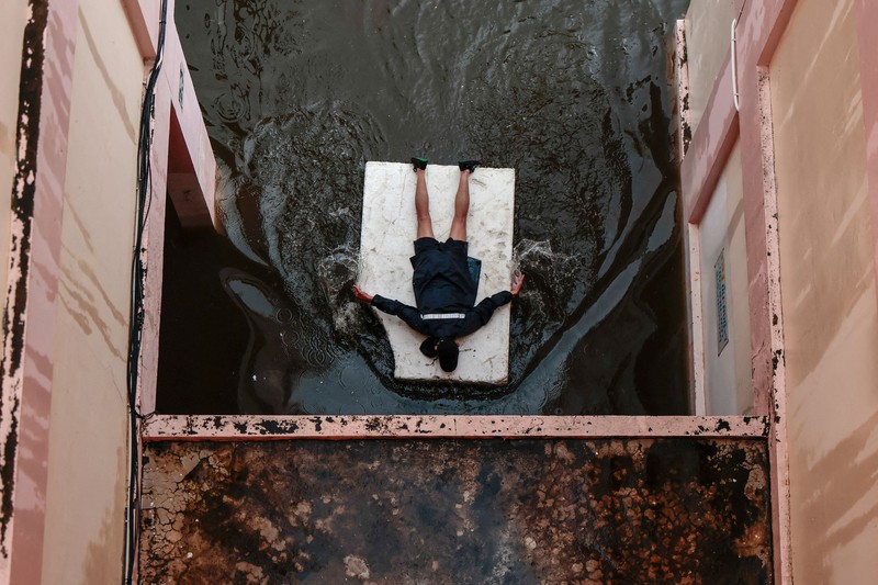 People are transported by a boat as others wade through a flooded area during heavy rain in Bangkok, Thailand, September 27, 2026. REUTERS/Patipat Janthong