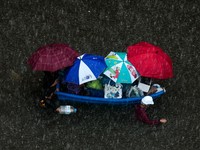 People are transported by a boat as others wade through a flooded area during heavy rain in Bangkok, Thailand, September 27, 2026. REUTERS/Patipat Janthong